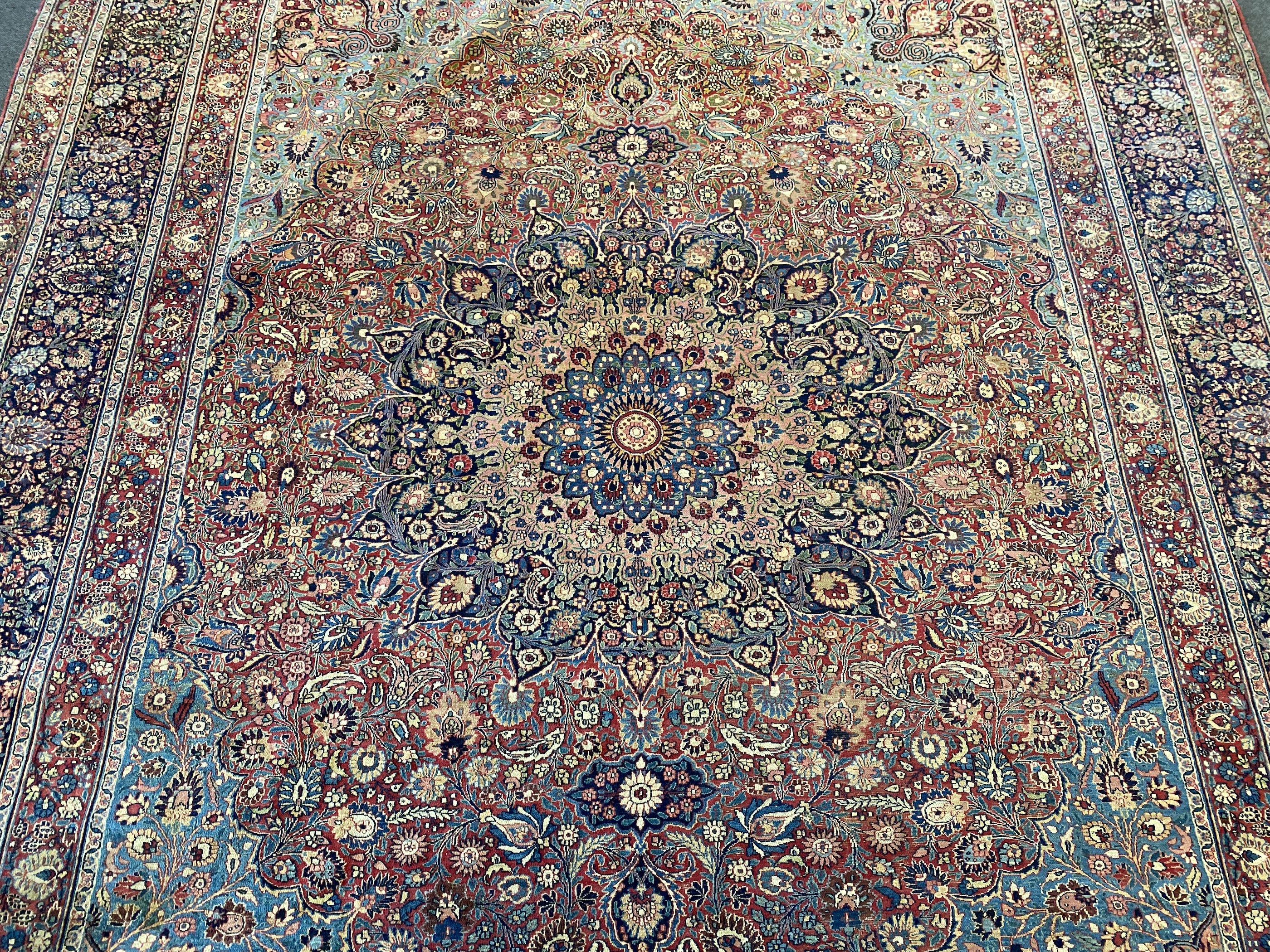 A large Persian blue ground carpet, 395 x 305cm